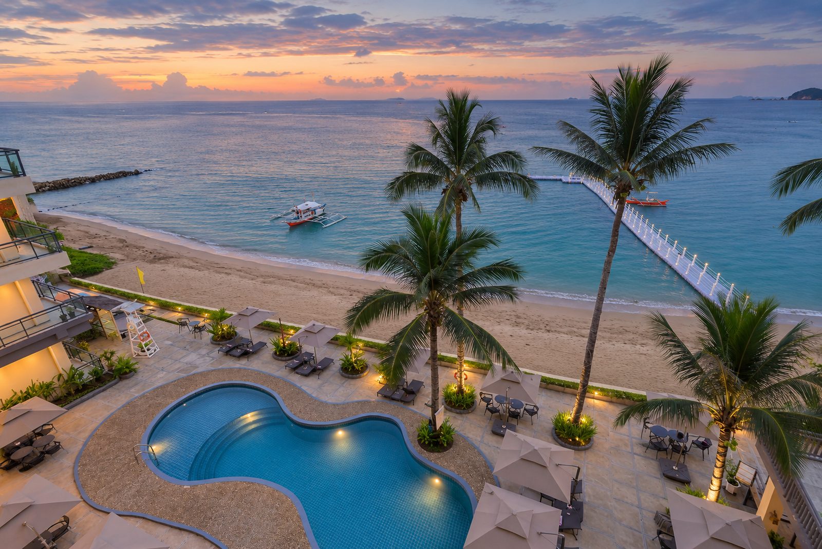 Twilight view over the pool and beach at Yunara Resort Busuanga